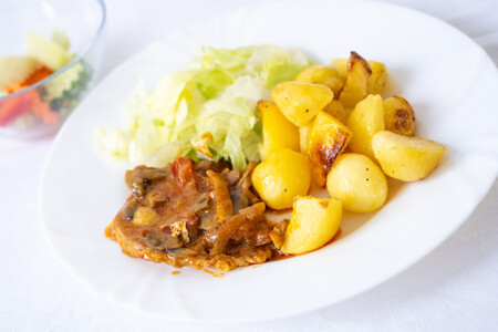 Novohradský vepřový plátek, opečené brambory, ledový salát