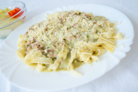 Tagliatelle se šunkou a krémovou špenátovou omáčkou sypané parmezánem