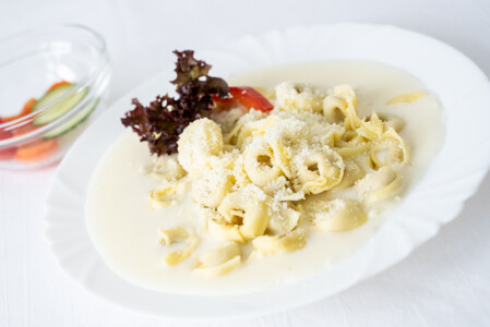 Tortellini plněné masem se sýrovou omáčkou, sypané parmezánem