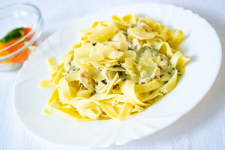 Tagliatelle s kuřecím masem a listovým špenátem sypané parmezánovými hoblinkami